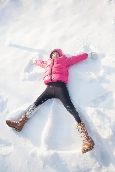 Menina faz anjo da neve — Fotografia de Stock
