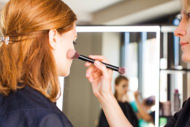 Genç kadın stüdyo profesyonel makyaj yapmak.