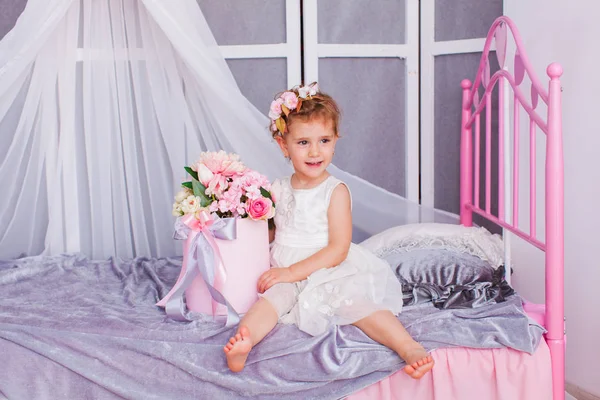 Bebê menina sentado em sua cama vestindo headband — Fotografia de Stock