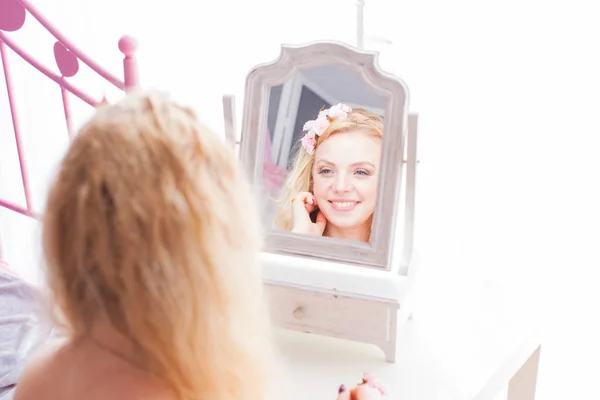 Attraktiv kvinna leende till hennes reflektion i spegeln — Stockfoto