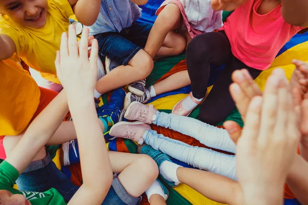 Masse von Kinderbeinen auf buntem Boden — Stockfoto