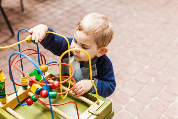 Мальчик играет с разноцветной игрушкой — стоковое фото