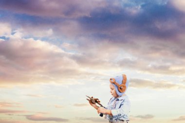 Küçük çocuk pilot günbatımı gökyüzü üzerinde