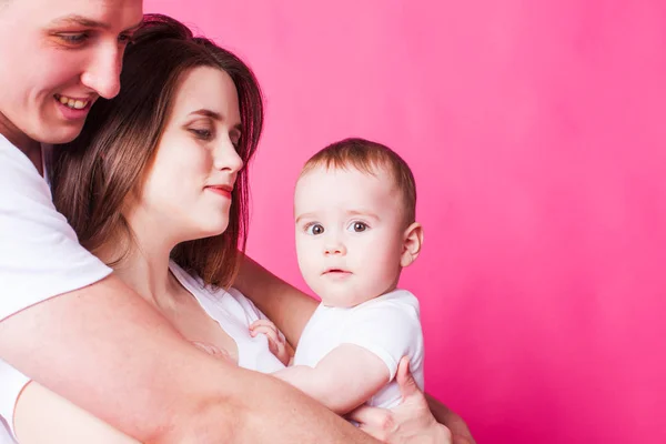 Bella famiglia è in posa con il loro bambino, sfondo rosa — Foto Stock