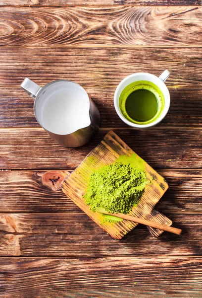 Tè Matcha con tè verde in polvere e brocca di latte su una scura tavola di legno rustico . — Foto Stock