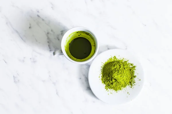 Una taza de té matcha verde con té matcha en polvo aislado sobre un fondo claro . — Foto de Stock