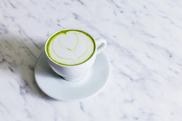 Una tazza di cappuccino Matcha con latte art su fondo chiaro . — Foto Stock