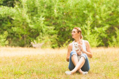 Çekici kadın ile kedi diz çimenlerin üzerinde oturuyordu