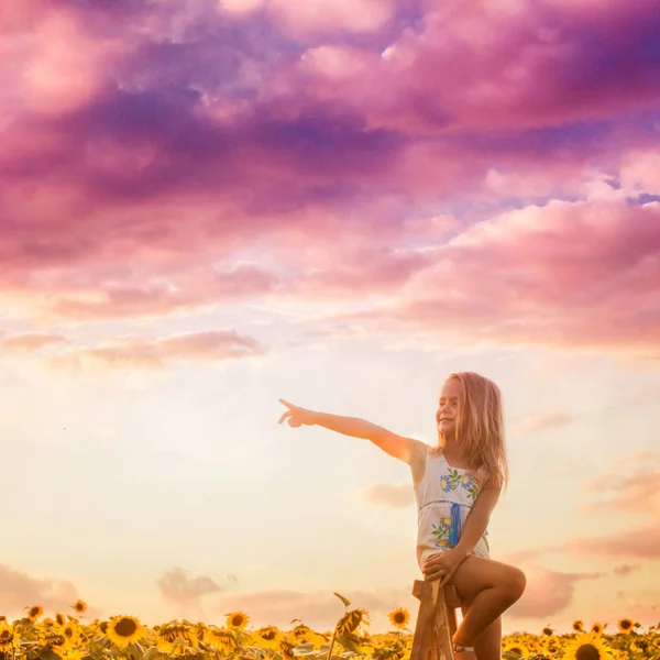 Das Mädchen schaut sich im Sonnenblumenfeld um — Stockfoto