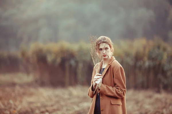 Одинокая девушка на прогулке в осеннем поле — стоковое фото