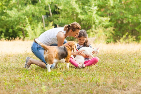 Dochter en haar moeder spelen met hun huisdieren — Stockfoto