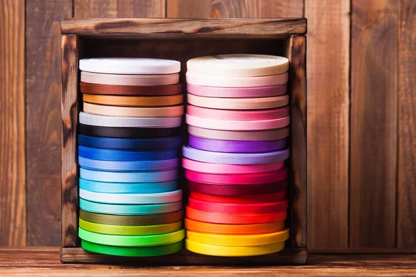 Colorful ribbon bobbins in the wooden box — Stock Photo, Image