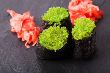 Tobiko yeşil suşi ve kırmızı Marine zencefil dilimleri