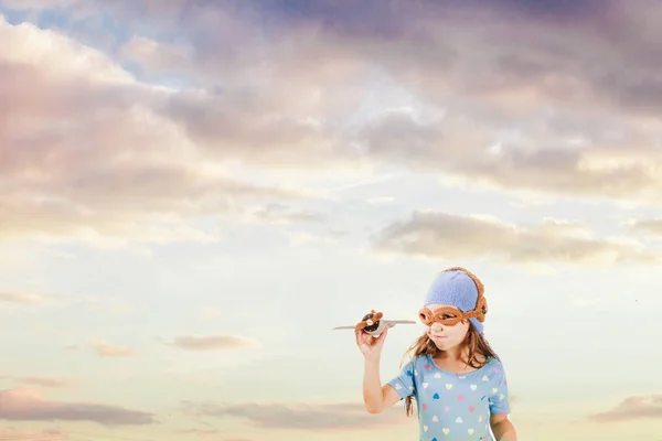 Menina feliz brincando com avião de brinquedo de malha — Fotografia de Stock
