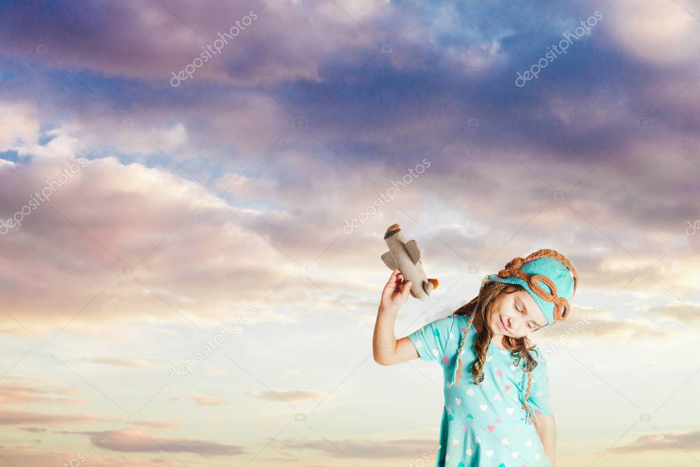 Mused child girl fantasizing herself as a pilot