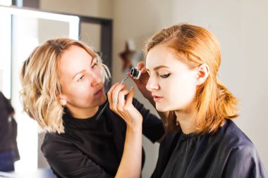 Genç kadın stüdyo profesyonel makyaj yapmak.