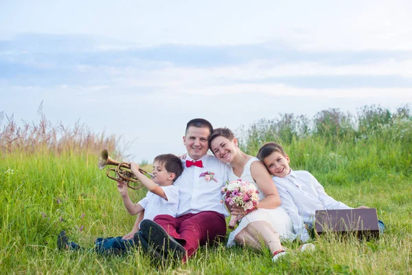 Романтическая семья в поле в вечернее сияние — стоковое фото