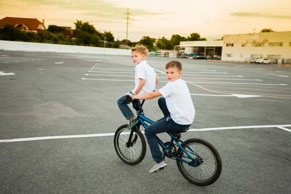 Dwóch braci pokazuje swoje umiejętności na jednym rowerze — Zdjęcie stockowe