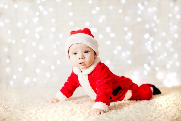 Pequeño bebé de Santa sobre la pared desenfocada luces — Foto de Stock