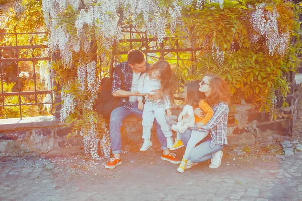 Famiglia giovane che ha riposo sotto l'albero fiorente — Foto Stock