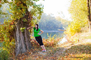 Güzel kadın ayakta büyük eski tree yakınındaki germe