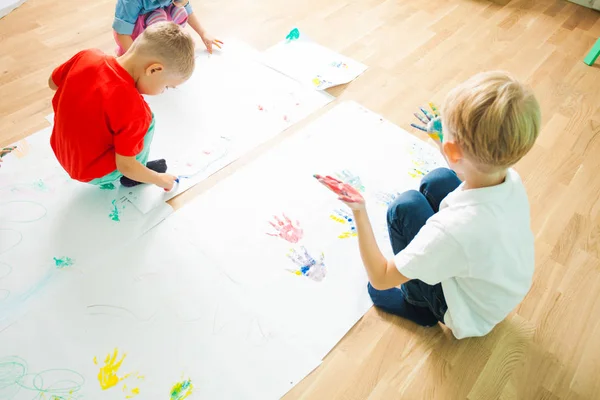 Top view of two kids drawing on a floor — Stock Photo, Image
