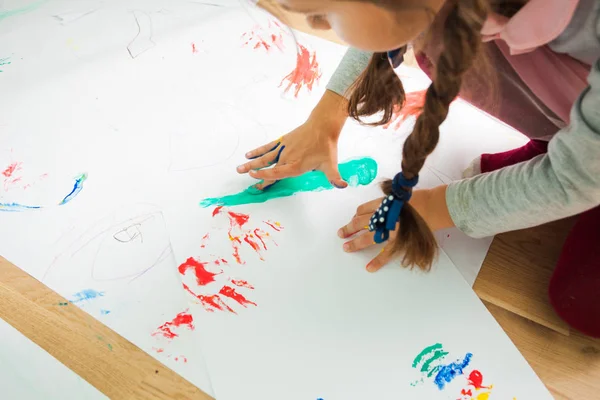 Fille peinture avec ses doigts sur une grande feuille de papier — Photo