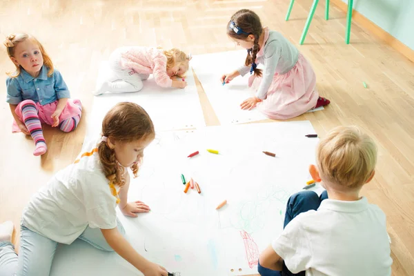 Bovenaanzicht van schattige kinderen tekenen op een verdieping — Stockfoto