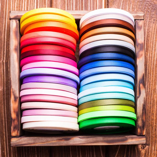 Ribbon bobbins in the wooden box close up — Stock Photo, Image