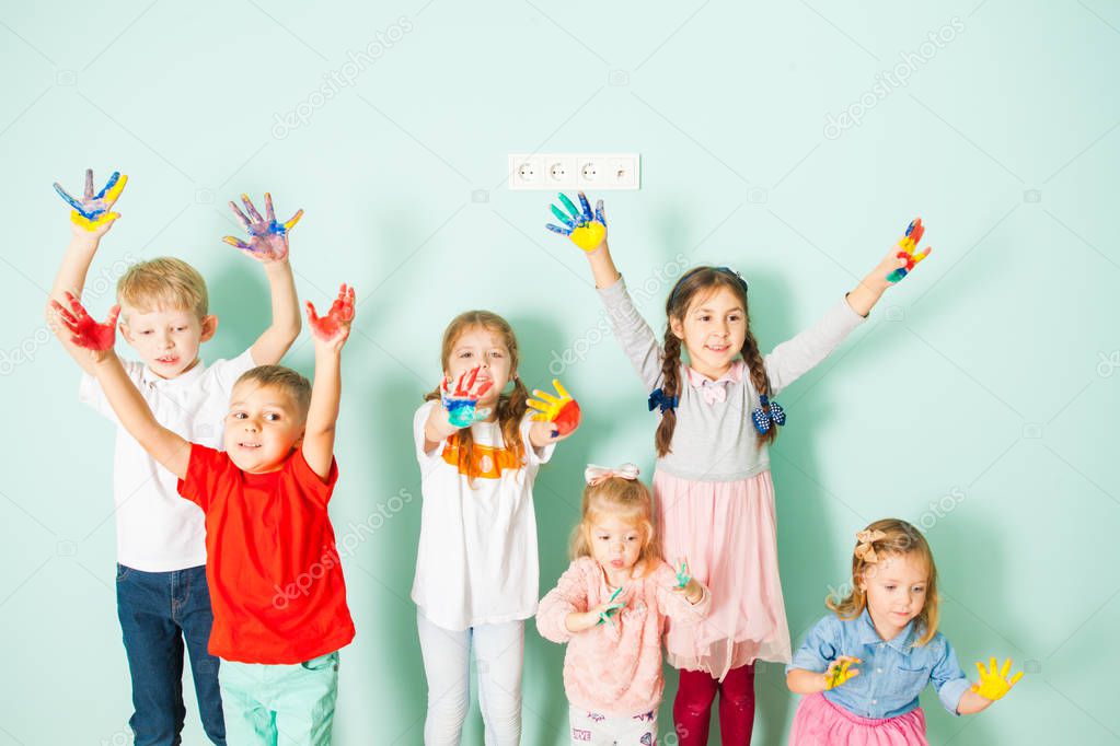 Happy kids holding their colored hands up