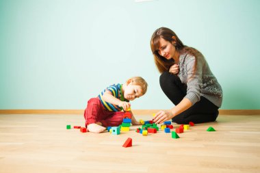 Neşeli anne çocuğunu yatak ile oynarken