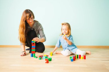 Anne ve küçük kızı ahşap blok bina