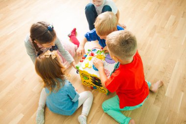 Büyük eğitici oyuncak ile evde oynayan çocuklar