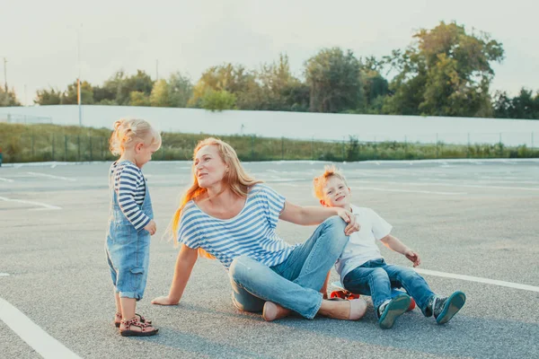 Mère assise sur un sol avec sa fille et son fils — Photo