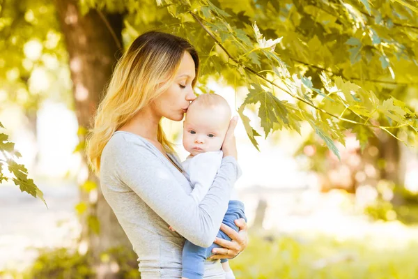 Cuidadora madre dando beso a su hijo — Foto de Stock