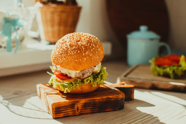 Sabrosa hamburguesa casera servida en un tablero rústico de madera —  Fotos de Stock