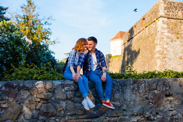 Romantický pár sedí na zdi blízko hradu — Stock fotografie
