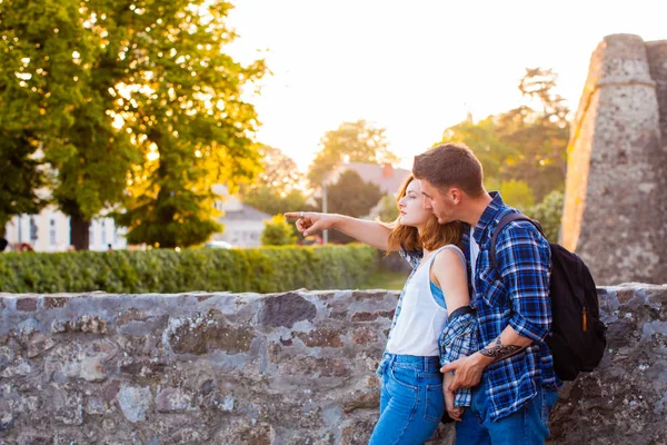 Joven hombre sosteniendo encantadora mujer cerca del castillo medieval — Foto de Stock