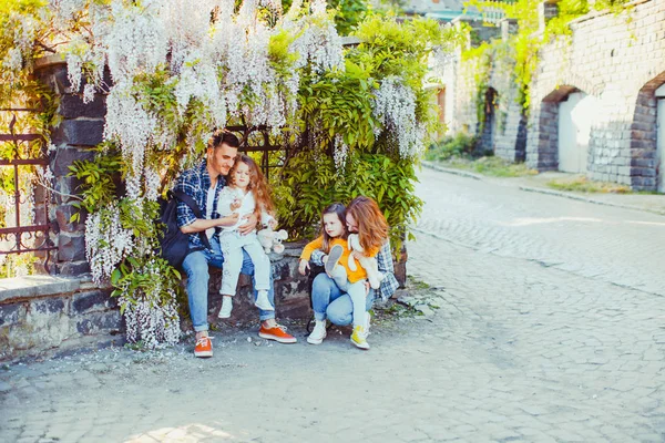 아래에 앉아 젊은 가족과 등나무 꽃 — 스톡 사진