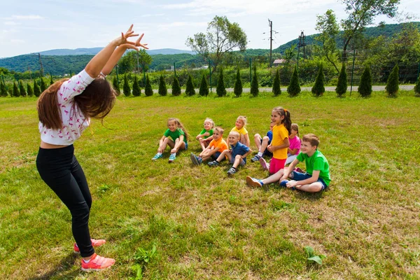 Bambini felici che indovinano durante il gioco delle sciarade al campo estivo — Foto Stock