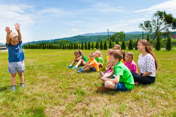 Schöner Junge, der vor einer Gruppe von Kindern steht — Stockfoto