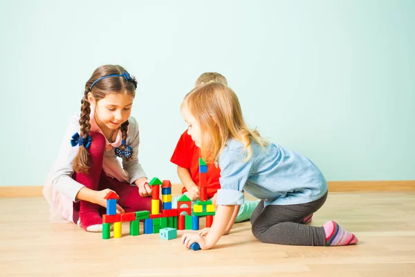 Enfants souriants jouant bâtiment de blocs colorés — Photo