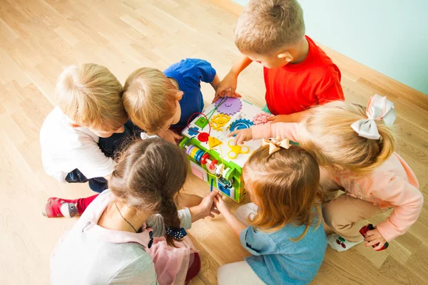 Sechs Kinder spielen mit neuem ungewöhnlichen Spielzeug — Stockfoto