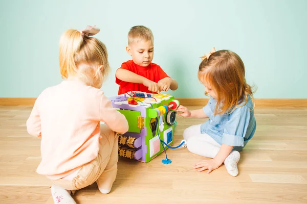Удивительный занятый куб и трое детей, играющих с ним — стоковое фото