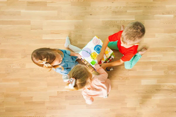 Вид сверху на детей, играющих дома с занятой доской — стоковое фото