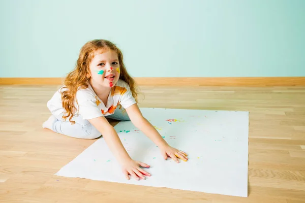 Portrait de petite fille peignant sur un sol avec ses mains — Photo