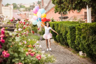 Kız parkta koşmak renkli lateks balonlar ile