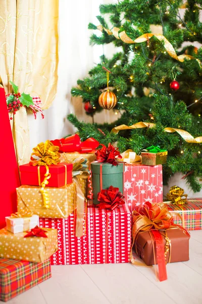 Weihnachtsgeschenke stapeln, Lichter am Weihnachtsbaum — Stockfoto