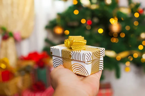 Christmas present in the hand over blurred defocused lights — Stock Photo, Image