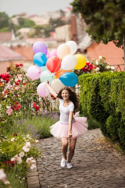 Menina com balões de látex coloridos correr no parque — Fotografia de Stock